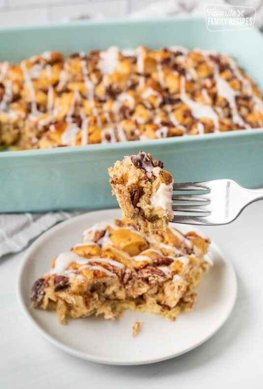 Cinnamon Roll Casserole on a fork held over plate.