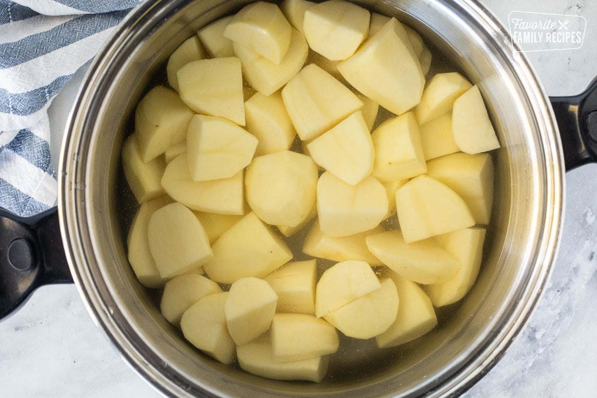 Peeled and cut potatoes in a pot of water.