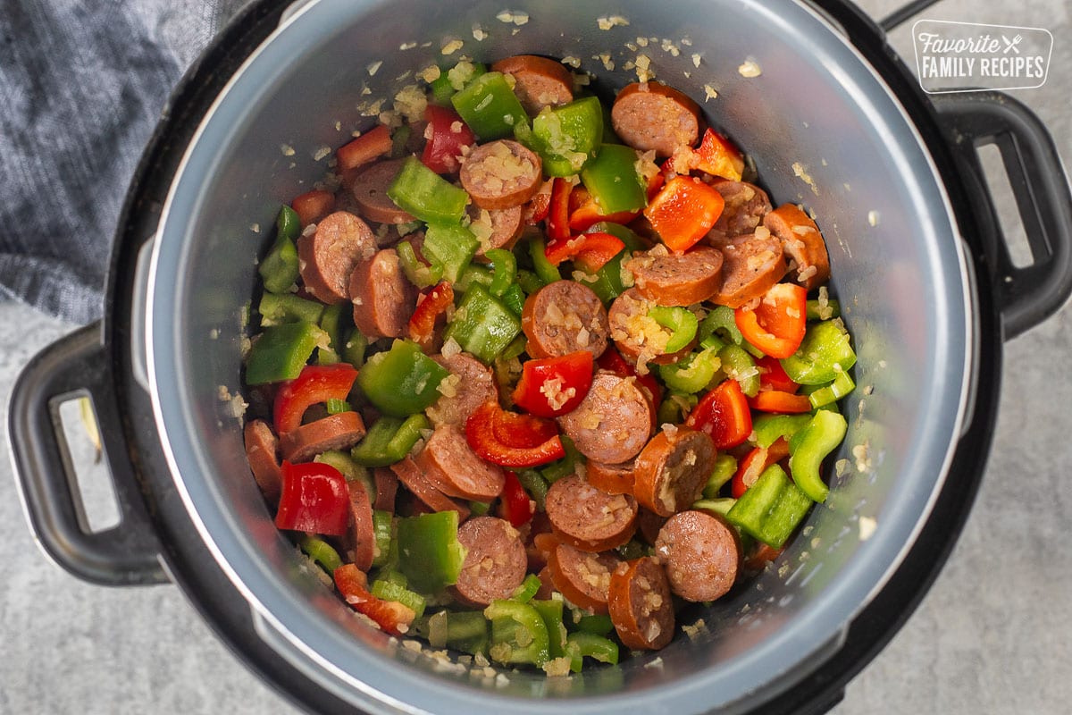 Instant pot with sautéed green and red peppers, onion, garlic and sausage.