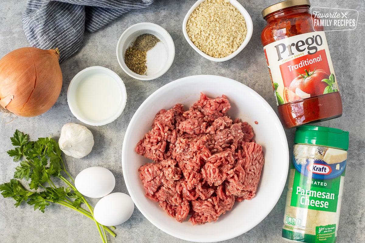 Ingredients to make instant pot meatballs including ground beef, marinara sauce, Parmesan cheese, Panko crumbs, seasonings, onion, eggs, garlic, and milk.