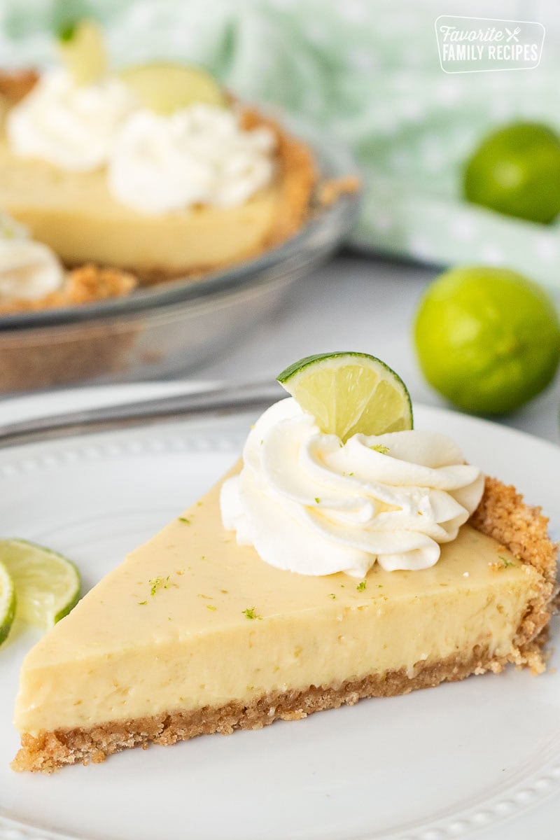 Close-up of Key Lime Pie slice with whipped topping and key lime zest, perfect texture filling.