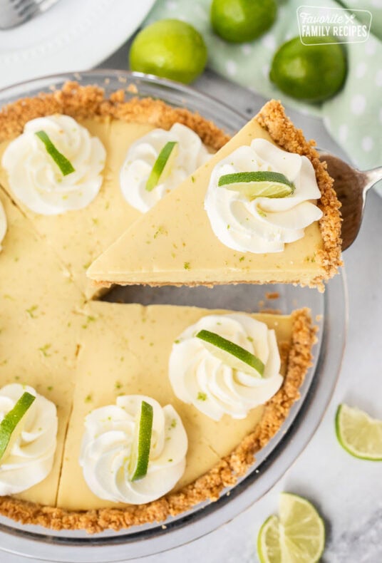 Slice of key lime pie being lifted from a whole southern key lime pie.