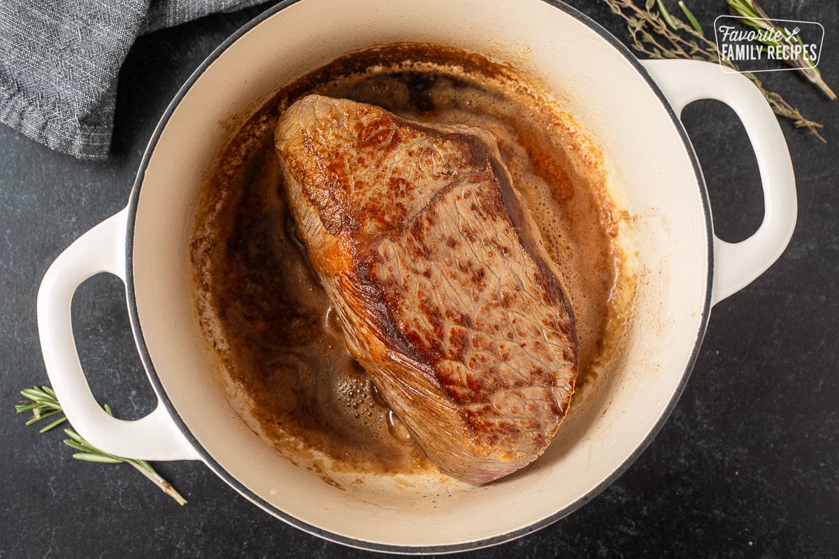 Dutch oven with browned beef roast.