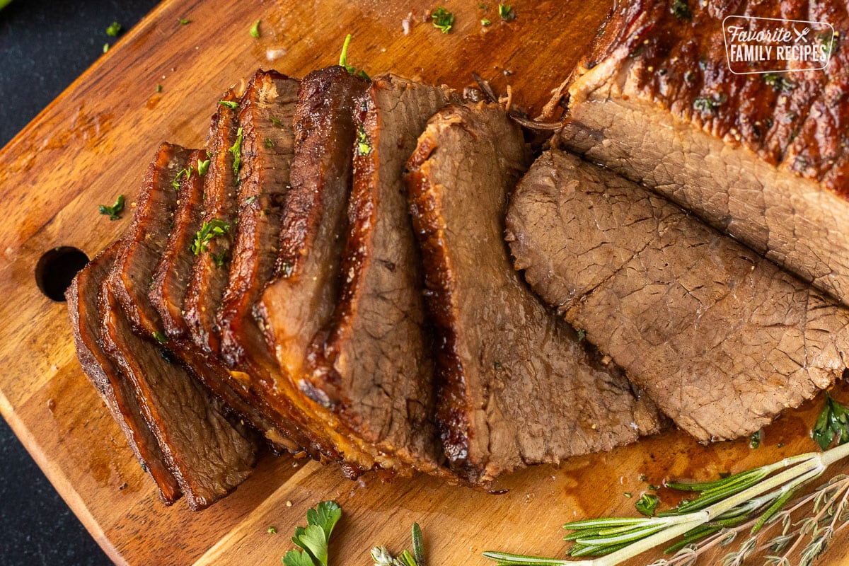 Sliced oven roast beef on a cutting board.