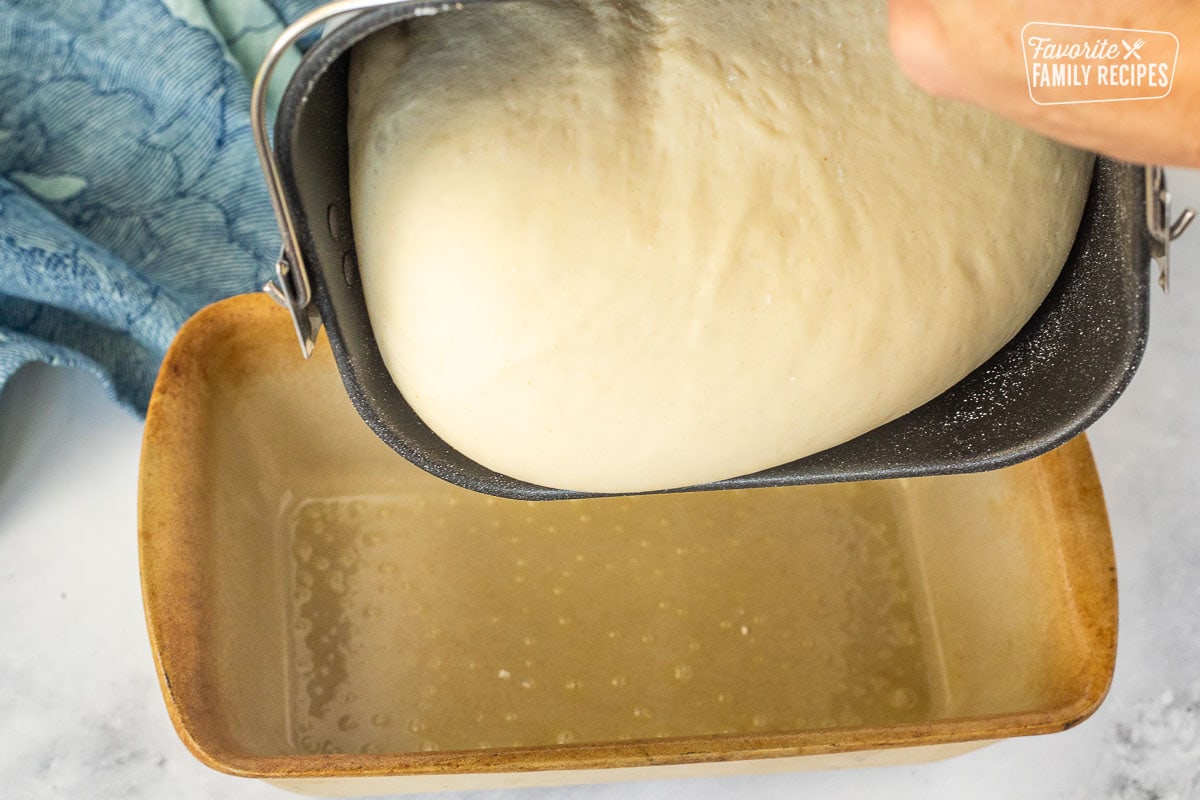 Pouring bread dough into greased pan.