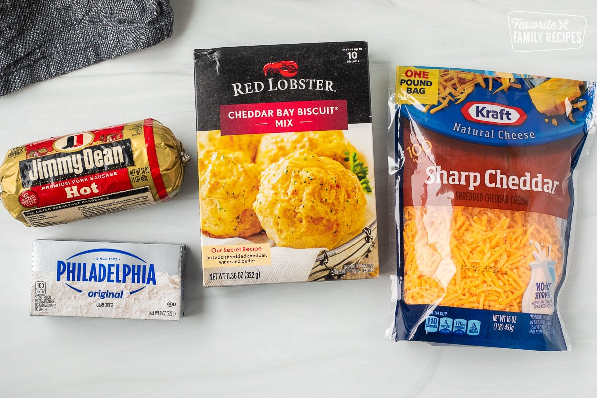 Ingredients to make Red Lobster Sausage Balls including shredded sharp cheddar cheese, Red Lobster cheddar bay biscuit mix, hot sausage and cream cheese.