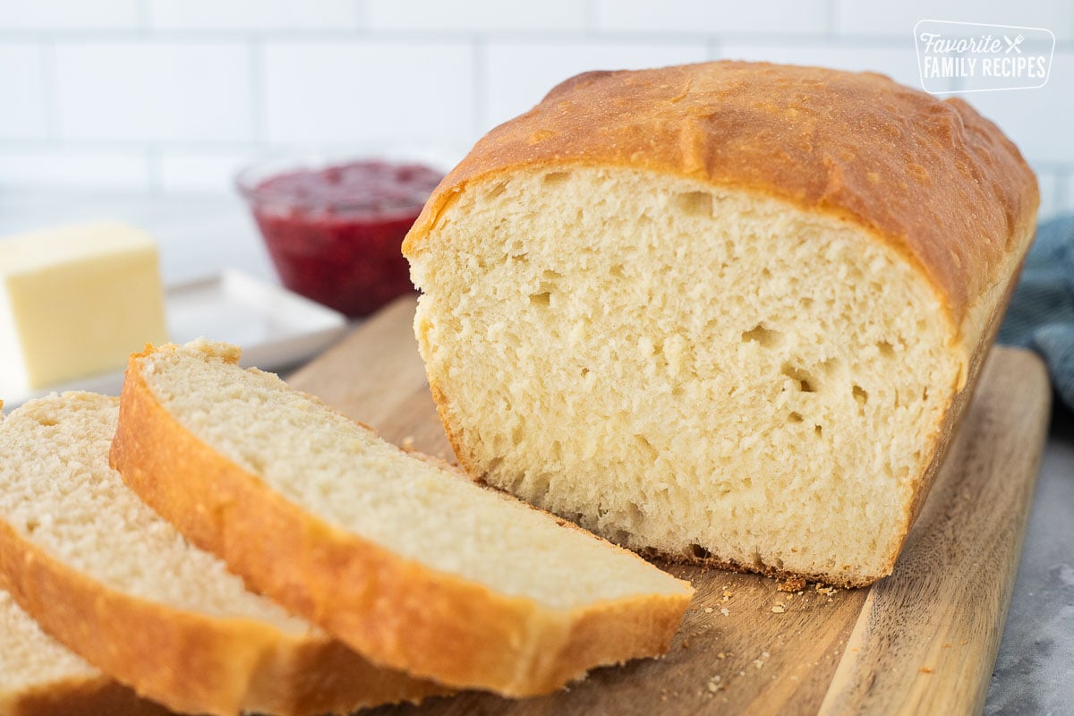 Sliced loaf of baked bread on a cutting board.