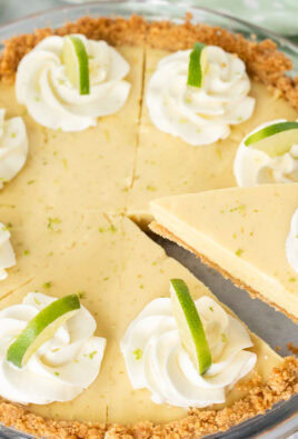 A slice of key lime pie being removed from the full pie with a pie knife