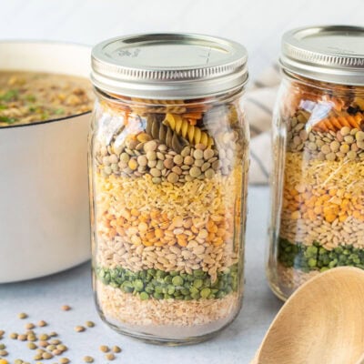 Two jars of dry soup ingredients. Pot of soup in the background.