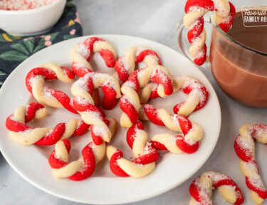 Plate of candy cane cookies next to a cup of hot cocoa.