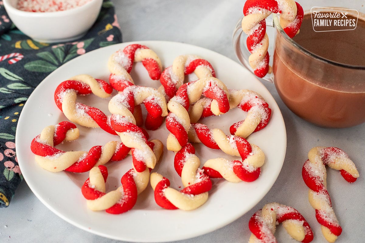 Plate of candy cane cookies next to a cup of hot cocoa.