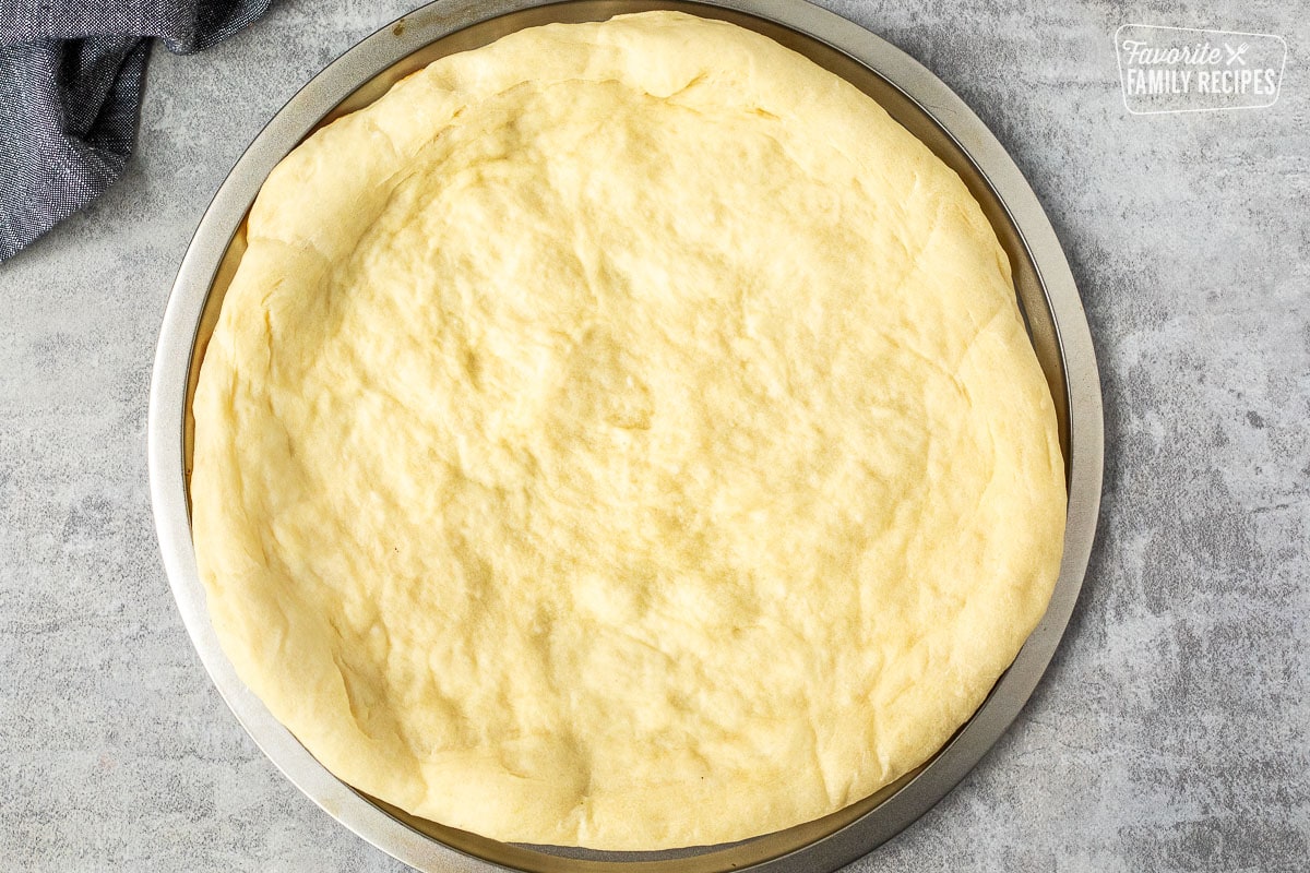 Baked pizza crust on a pizza pan.