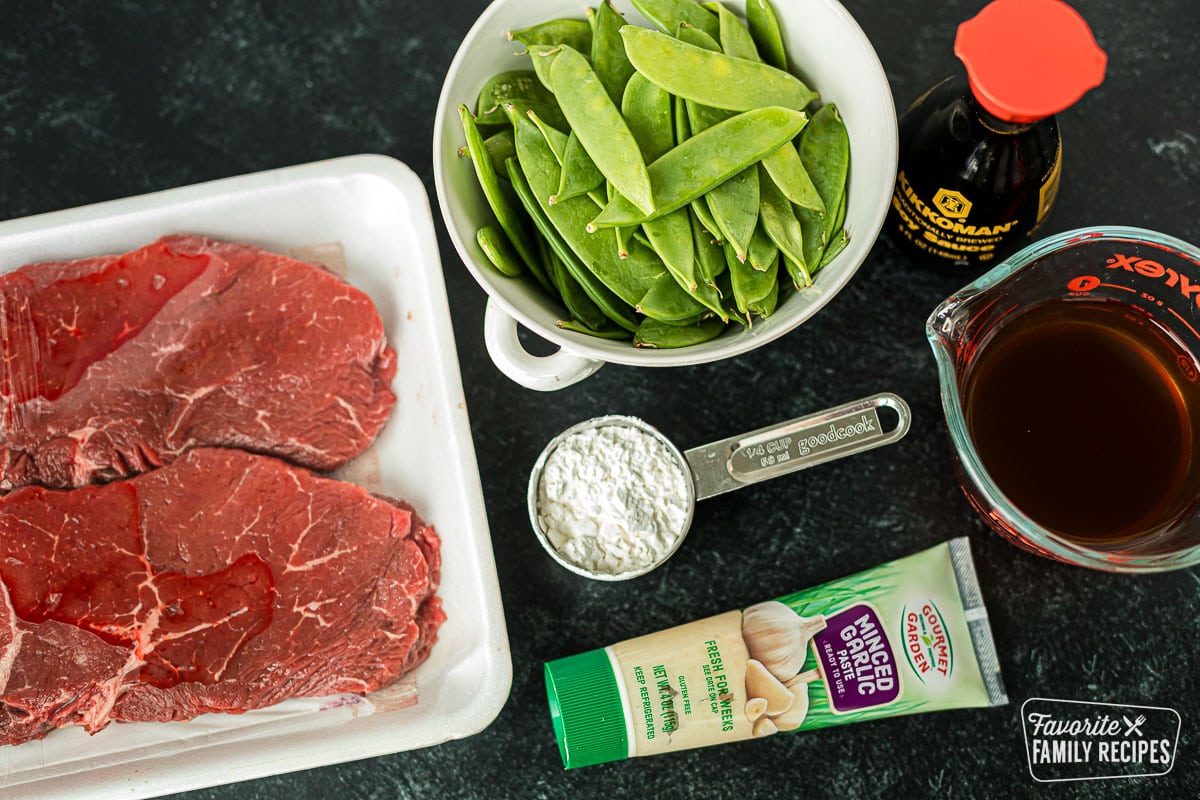 Ingredients to make beef and snow peas including top sirloin, snow peas, garlic, beef broth, soy sauce, and cornstarch