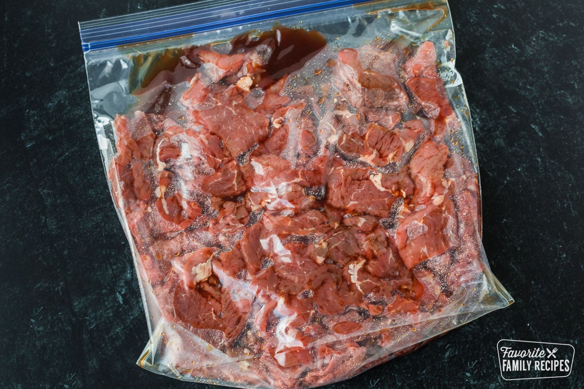 Sliced beef being marinated in a plastic bag