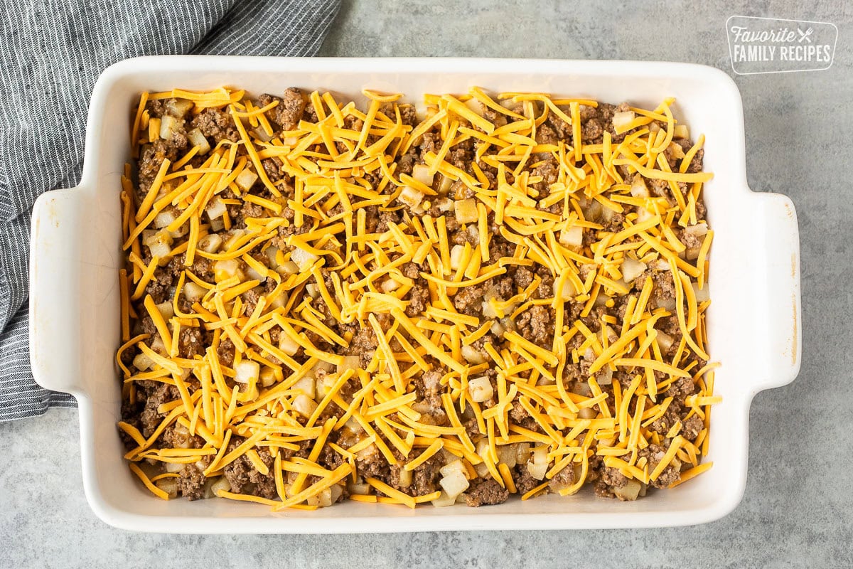 Casserole dish with ground beef, diced hash browns and cheese. Topped with shredded cheddar cheese.