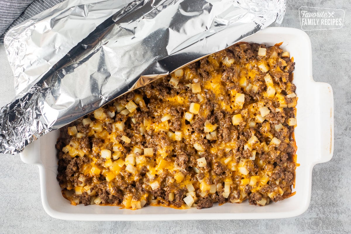 Cooked Big Mac Casserole in a dish removing foil.