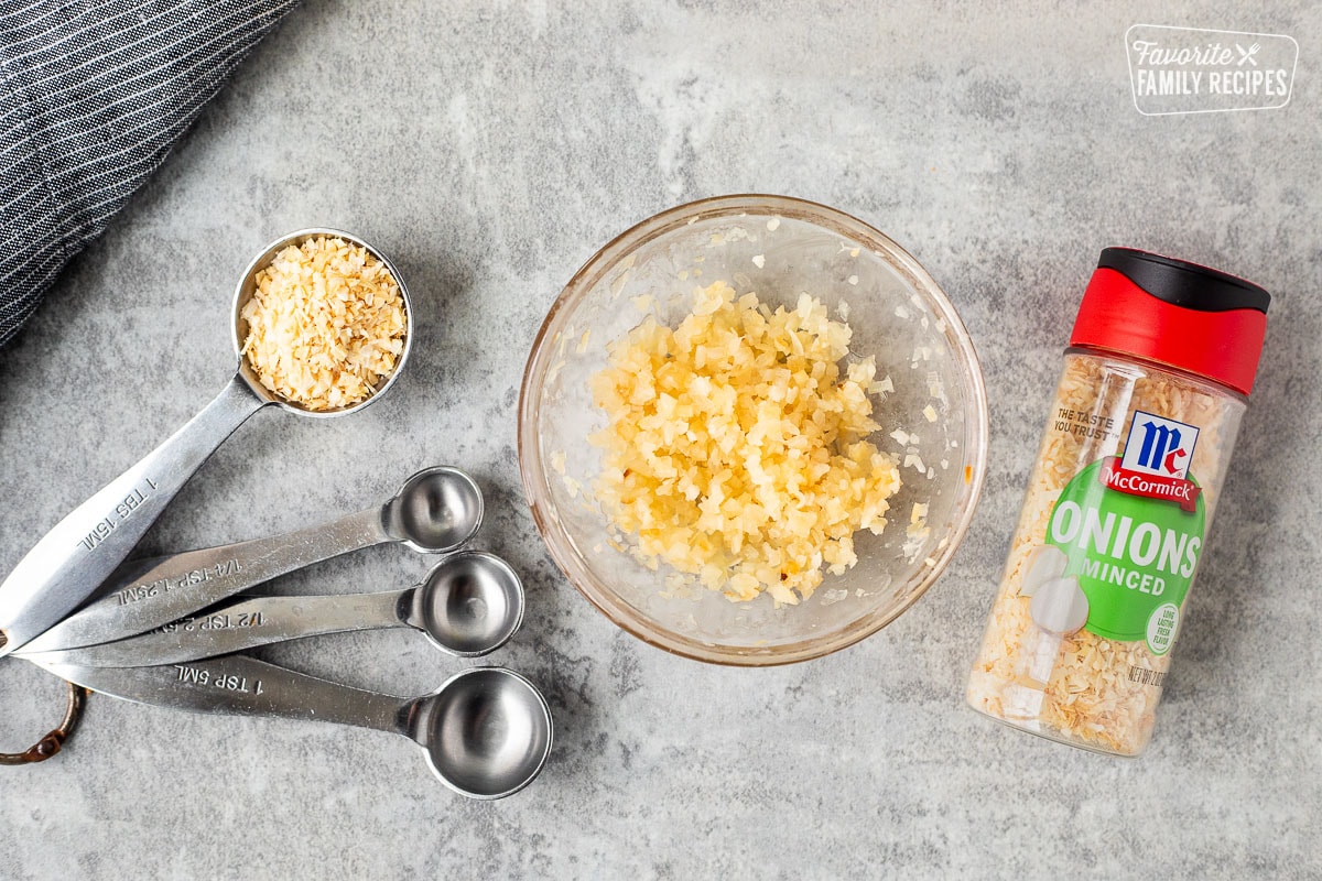 Hydrated minced onions in a small glass bowl and measuring spoons.