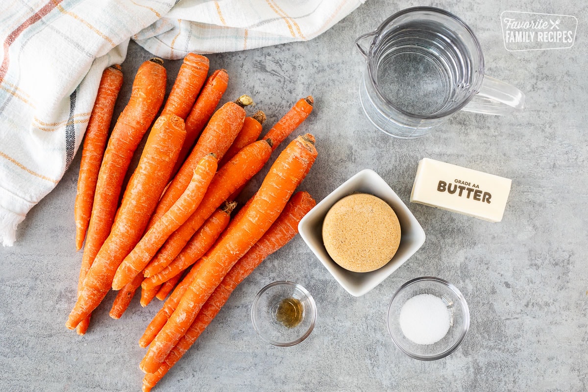 Ingredients to make candied carrots including carrots, brown sugar, butter, water, salt and vanilla.