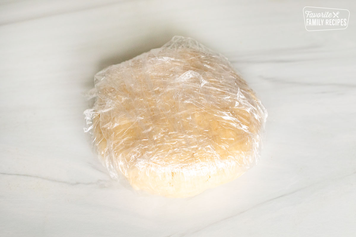 Pastry dough wrapped in plastic wrap.