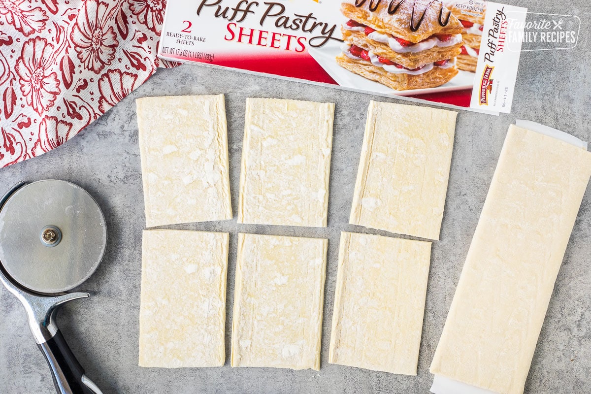 Rolled out, puff pastry sheet cut into six rectangles with a pizza slicer.