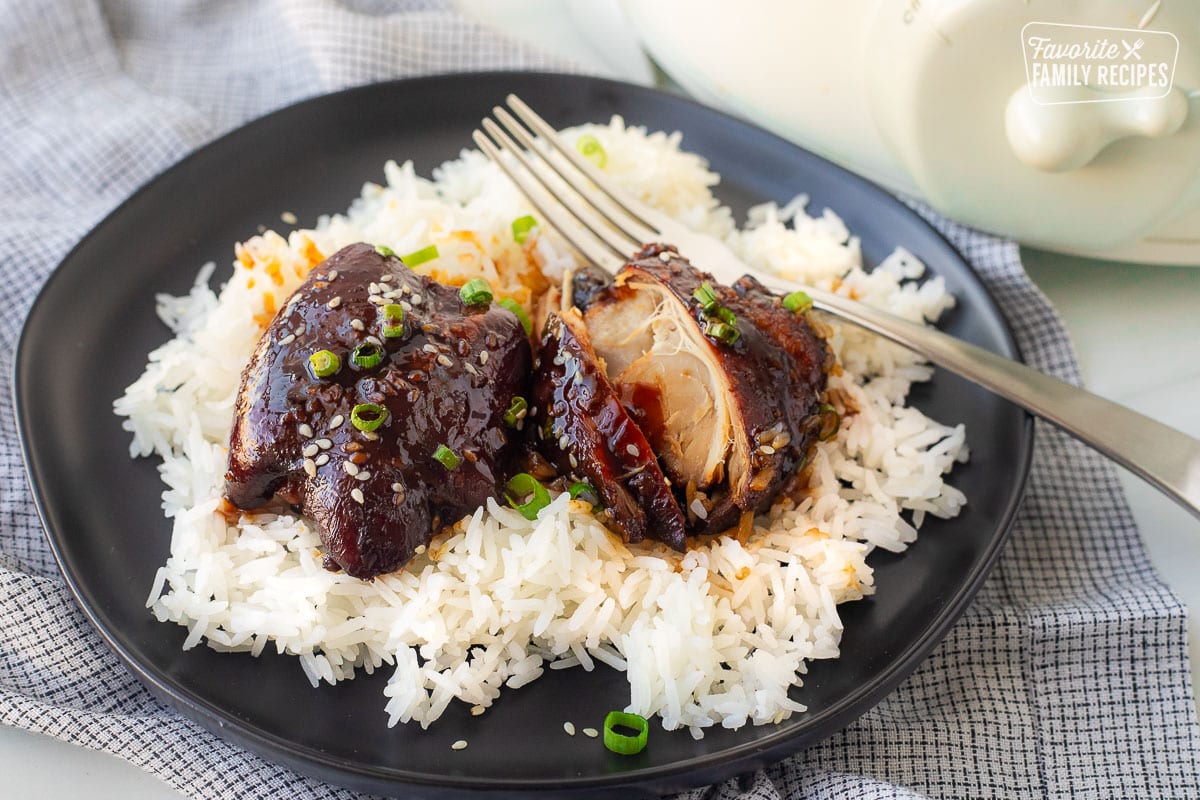 Crockpot Hawaiian chicken over rice on a plate with a fork.