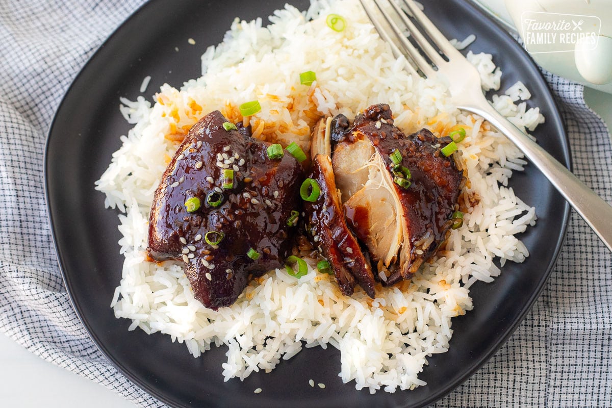 Crockpot Hawaiian chicken over rice on a plate with a fork.