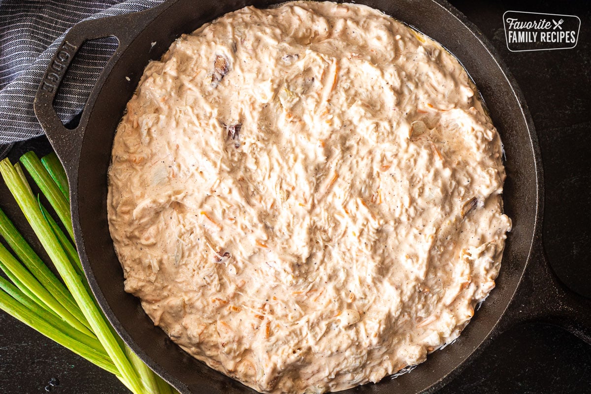 Skillet with Hot Crab Dip spread smooth.