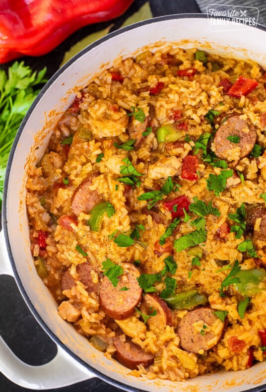 Dutch oven with Jambalaya garnished with fresh parsley and pepper.