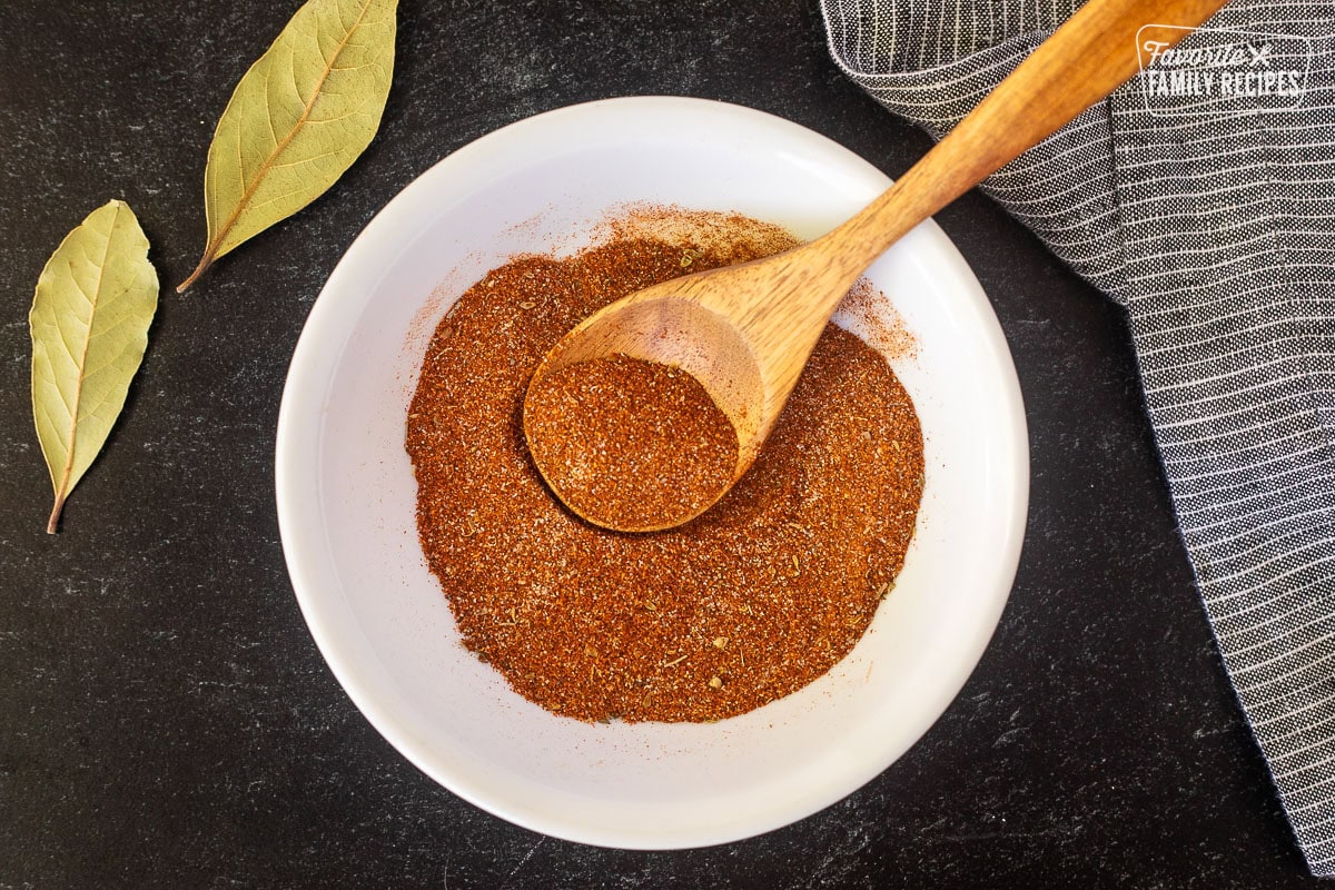 Small bowl with combined seasonings and wooden spoon.