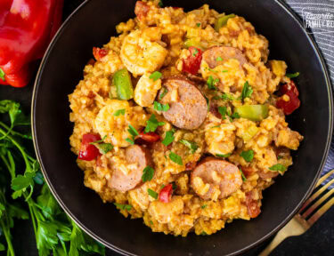 Bowl of jambalaya with sausage, shrimp, chicken and peppers.