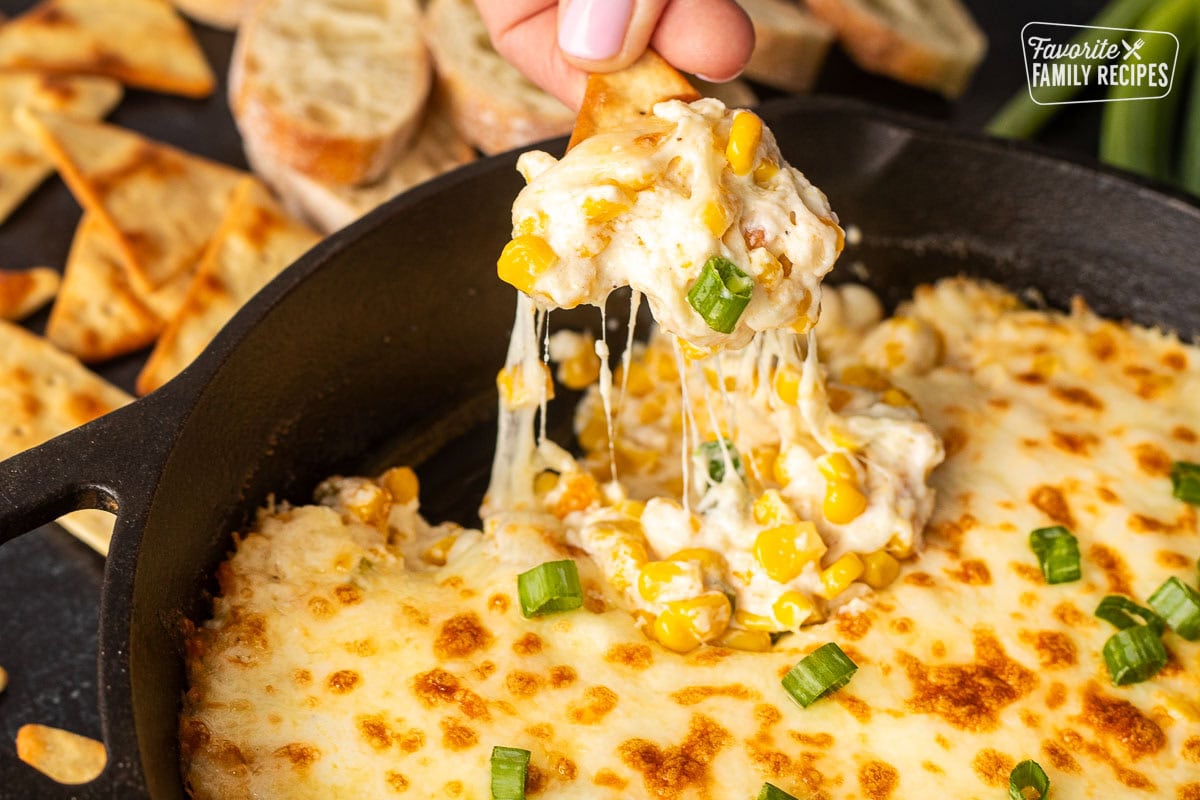 Chip pulling out Corn Cheese scoop out of a skillet.