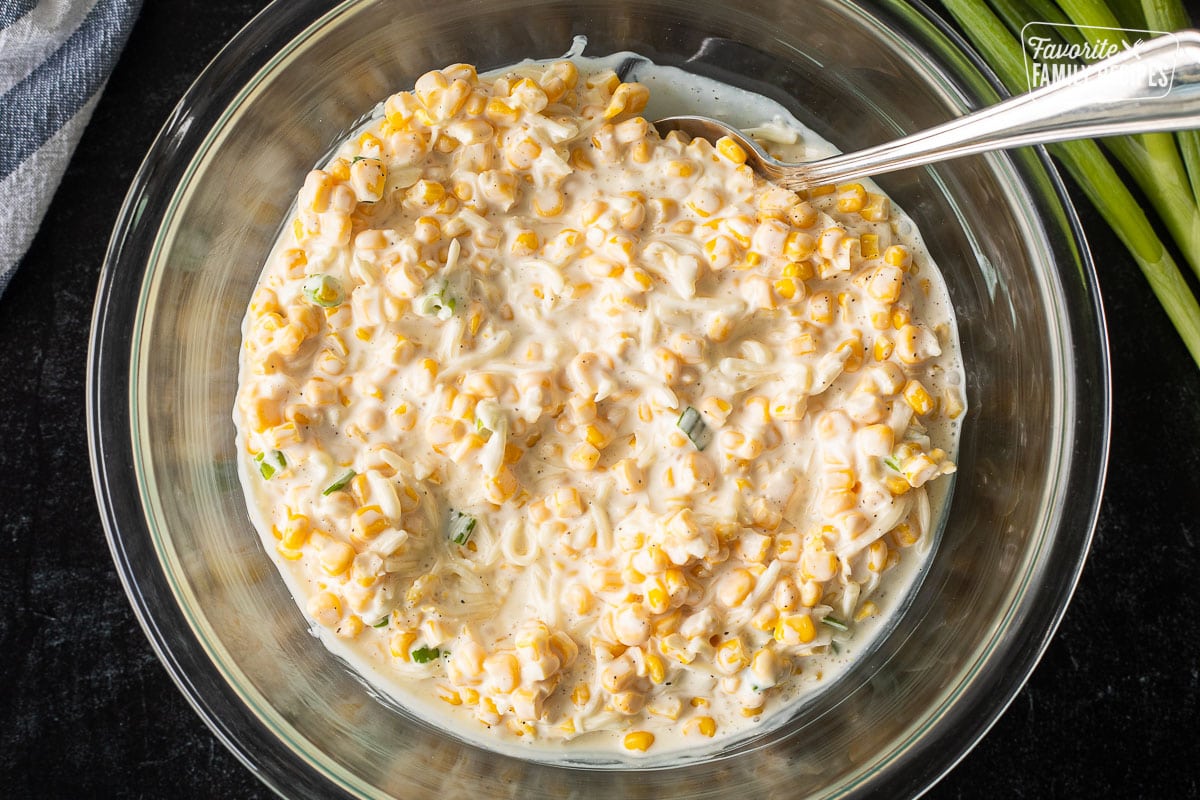 Mixing Corn Cheese ingredients in a bowl with a spoon.