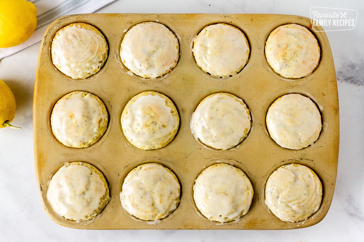 Muffin pan with twelve glazed Lemon Poppy Seed Muffins.