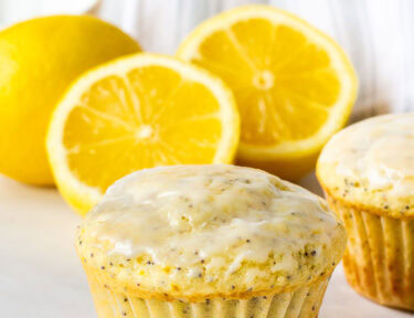 Lemon poppy seed muffin with lemons in the background.