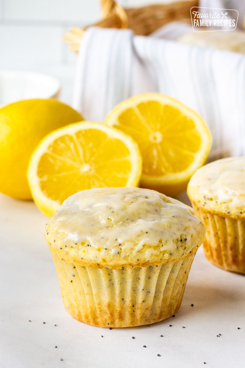 Lemon poppy seed muffin with lemons in the background.