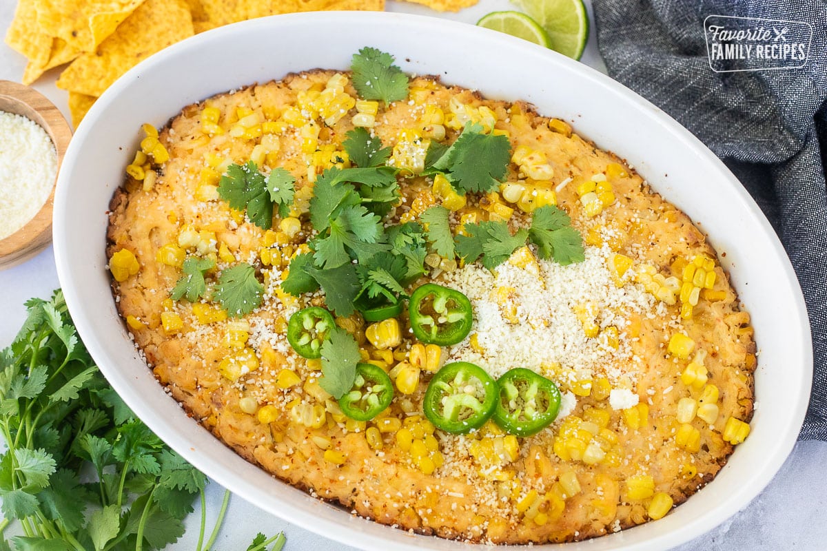 Baked Mexican Street Corn Dip in a dish toped with jalapeño, cilantro and cojita cheese.