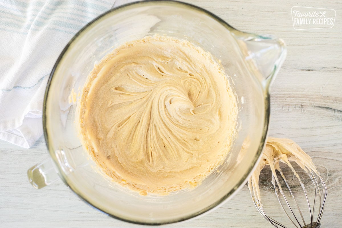 Mixing bowl of cake batter base with whisk attachment on the side.