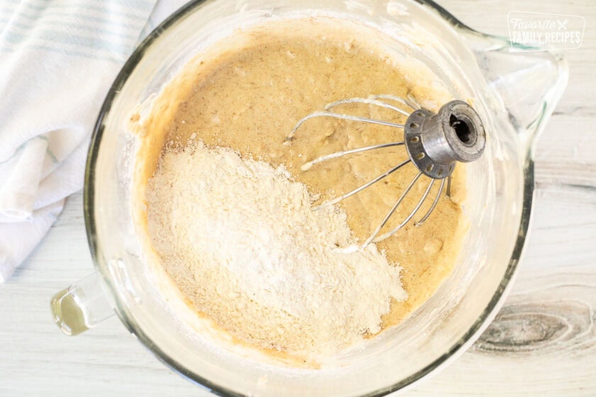 Glass mixing bowl with cake base, dry ingredients and whisk attachment.