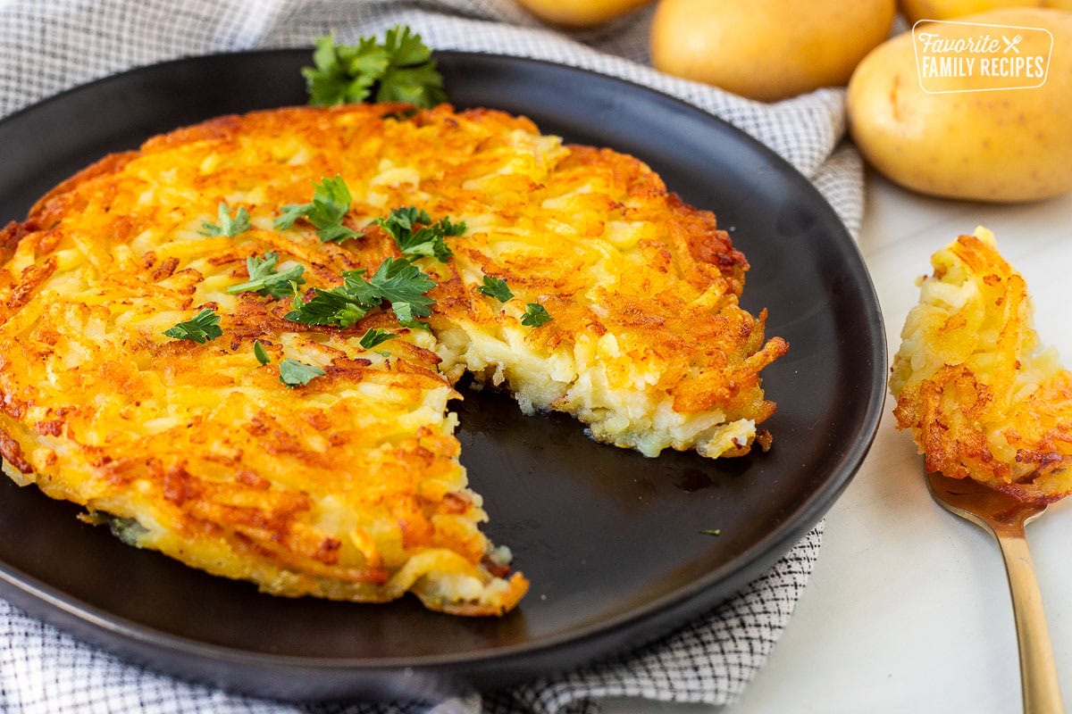 Rosti on a plate garnished with parsley and a cut out with a fork.