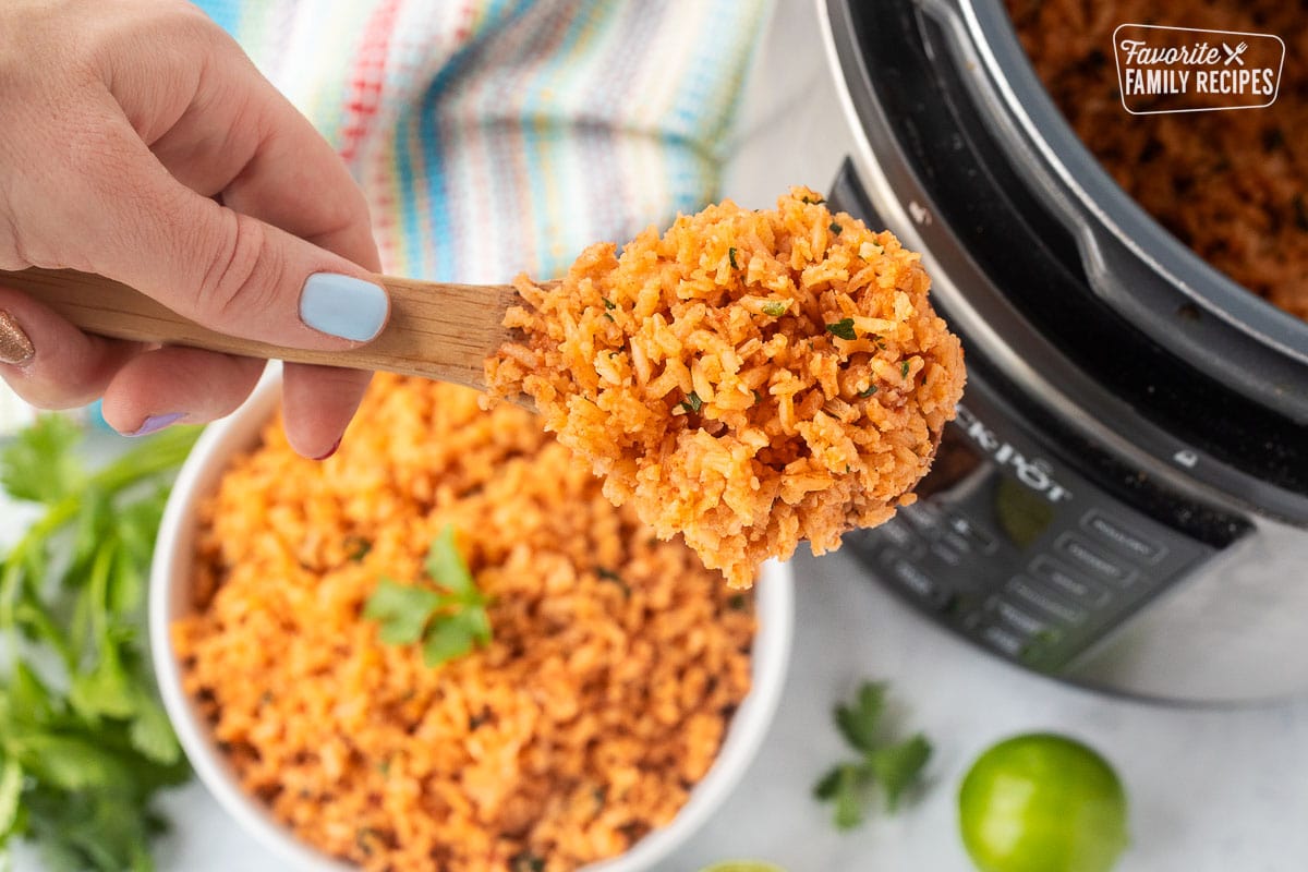 Wooden spoon holding a serving of instant pot Mexican rice.