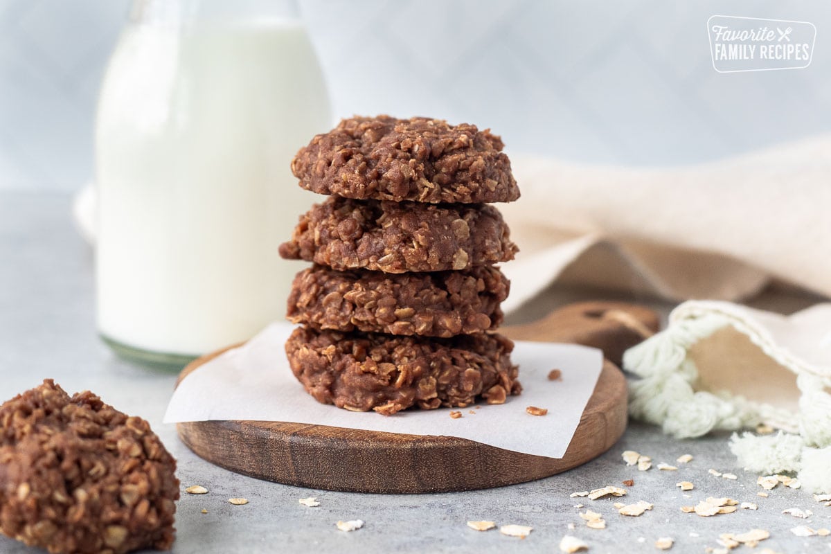 Four stacked no bake cookies with milk.