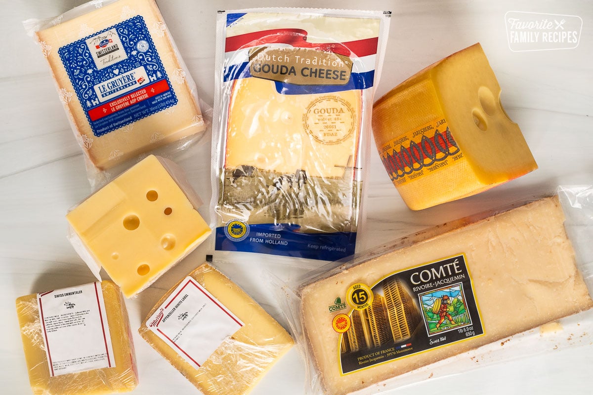 Different cuts of cheeses including gouda, Comte, appenzeller, Swiss emmentaler, Jarlsberg, gruyere.