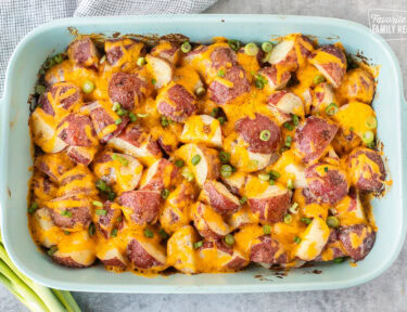 Cheesy Ranch Potatoes in a baking dish topped with green onions.