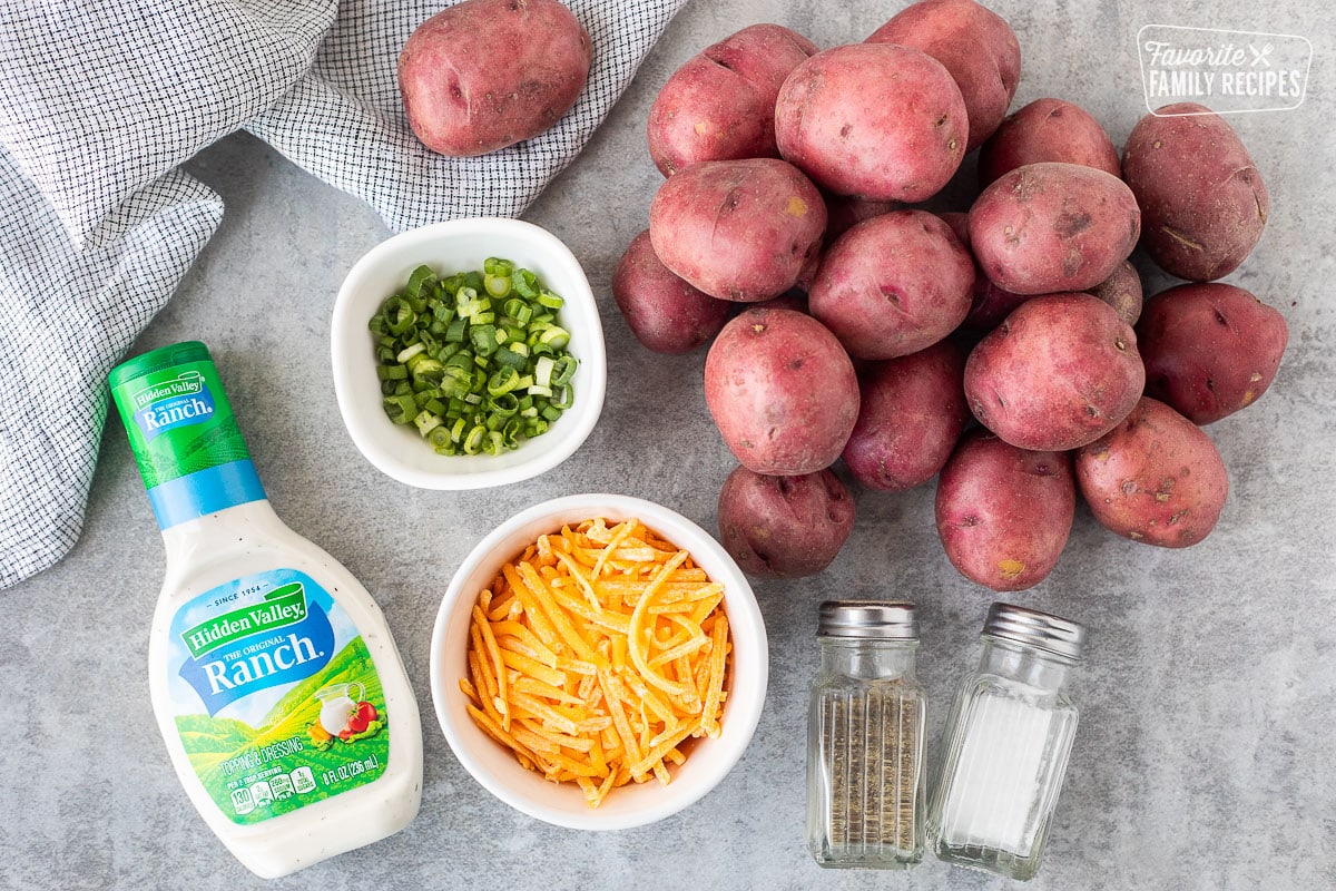 Ingredients for Cheesy Ranch Potatoes including red potatoes, ranch dressing, green onions, cheddar cheese, salt and pepper.