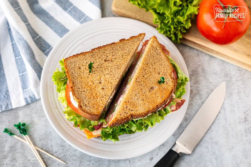 Club sandwich with wheat bread sliced in half with toothpicks.