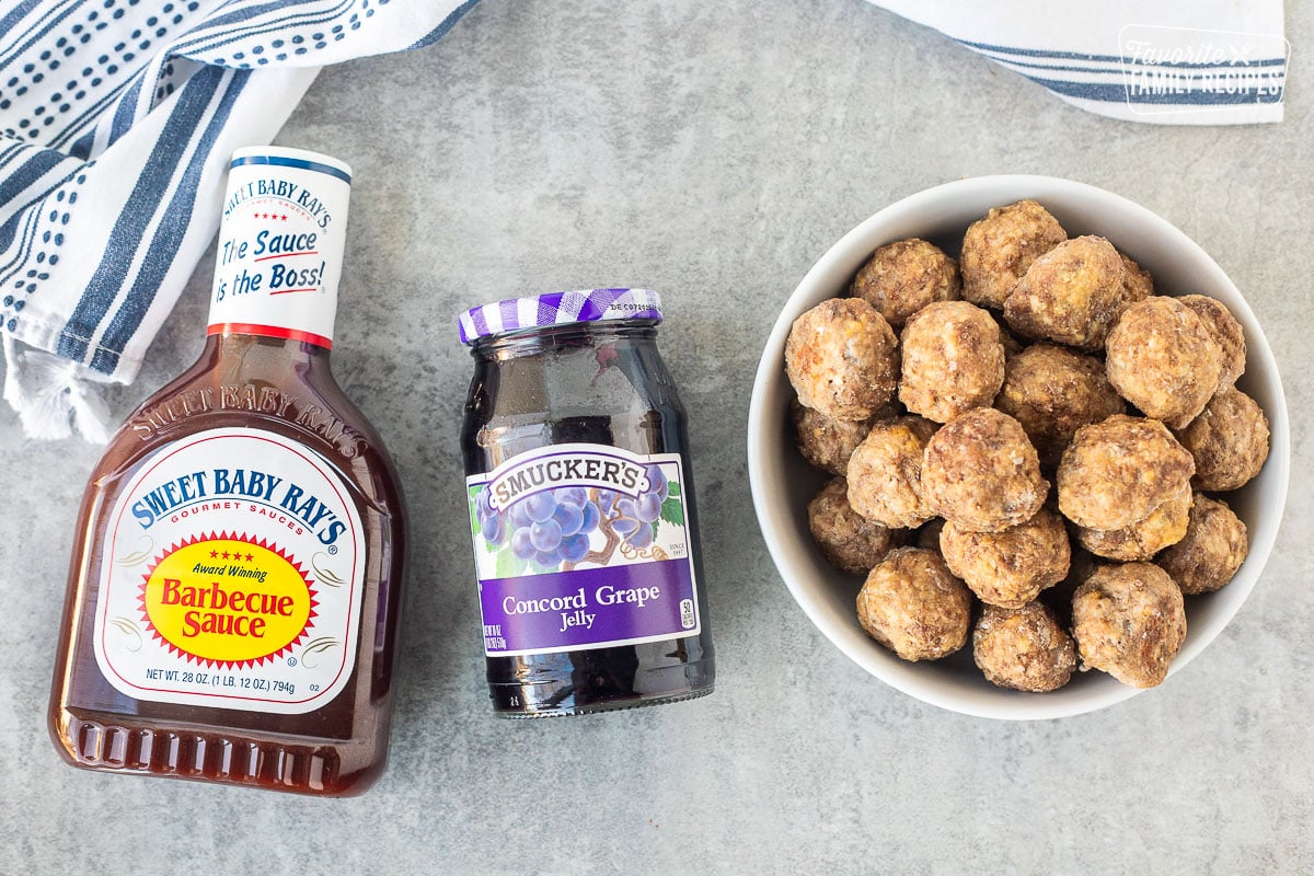 Ingredients to make grape jelly meatballs including Sweet Baby Ray's barbecue sauce, Concorde grape jelly, and frozen meatballs.