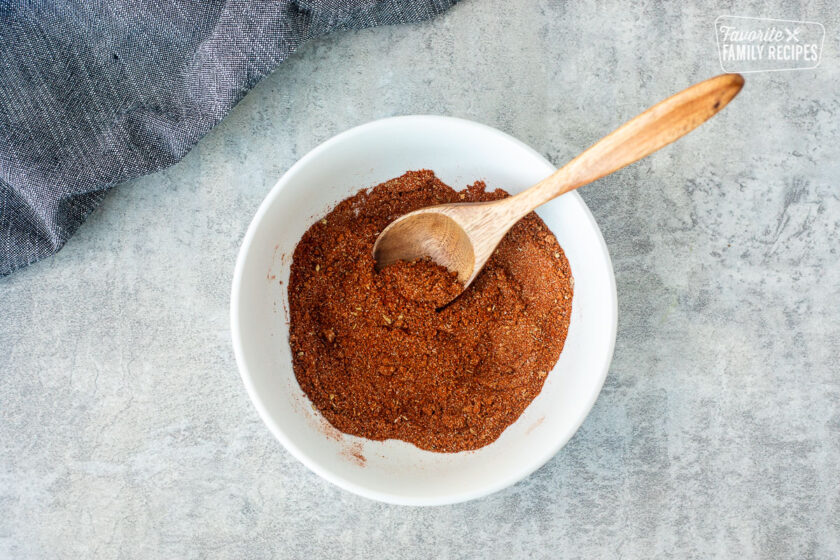 Dry seasoning for Filet Mignon rub in a mixing bowl with wooden spoon.