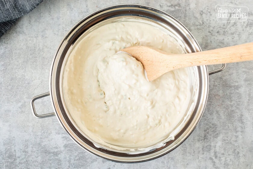 Blue Cheese sauce in a saucepan with a wooden spoon.