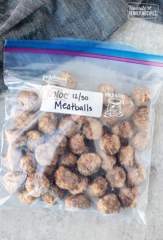 Frozen meatballs in a Ziplock freezer bag that has been labeled and dated and ready to be reheated.