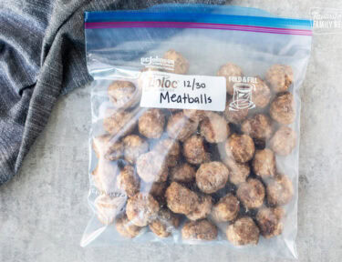 Frozen meatballs in a Ziplock freezer bag that has been labeled and dated and ready to be reheated.